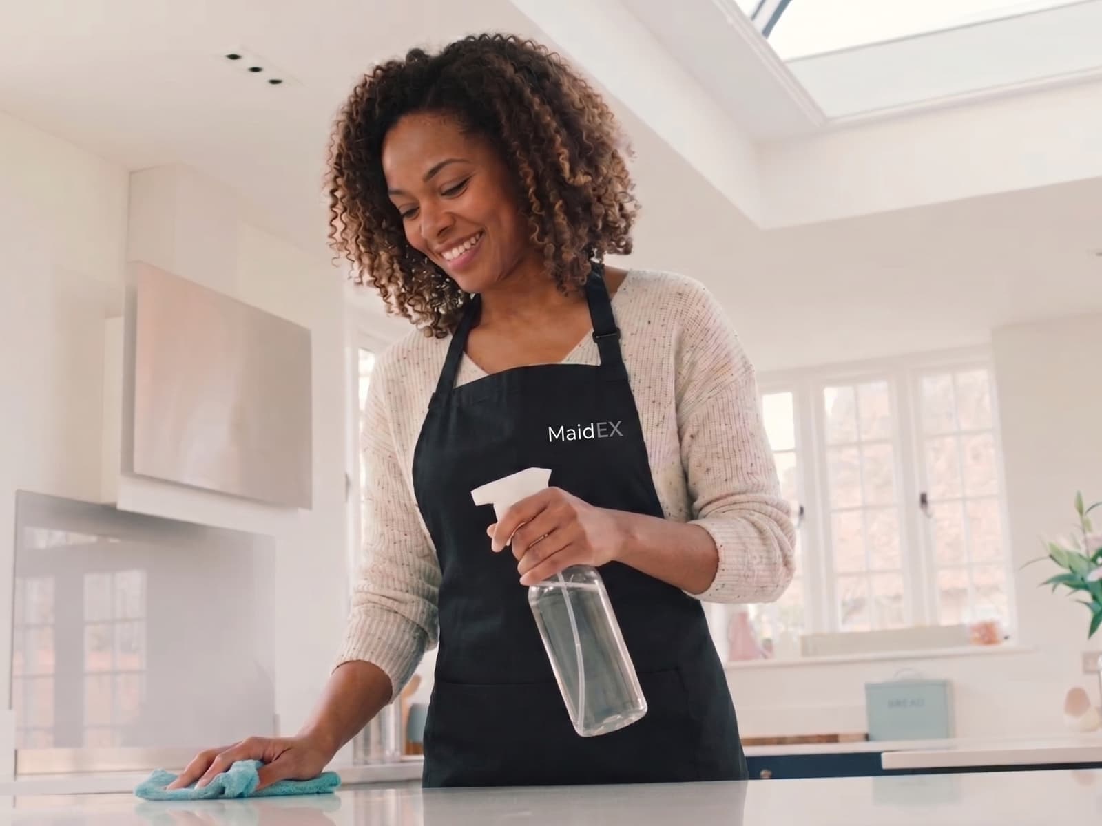 A MaidEX cleaner wiping down a kitchen counter